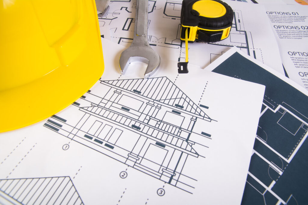 مكان عمل المهندس مع المخططات والمنقلة وخوذة السلامة